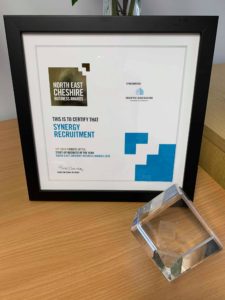 A picture of our award in a frame and the glass award on a desk