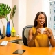 Smiling Office Manager or Executive Assistant sat at an office desk