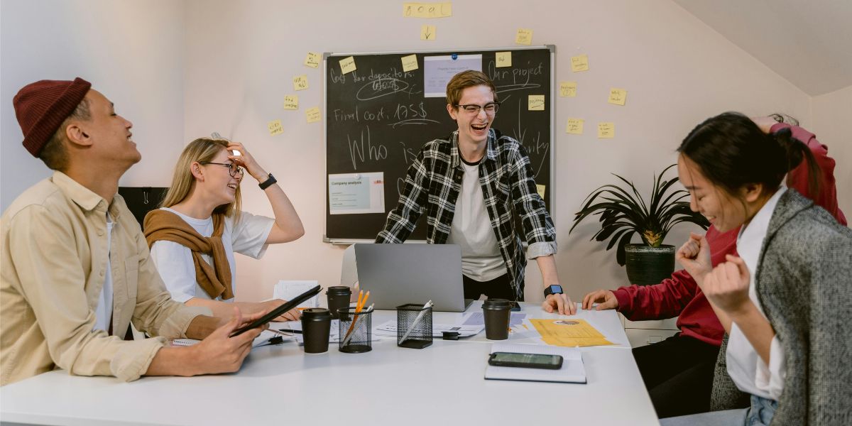 Colleagues sat around a desk, discussing their 'office personalities'