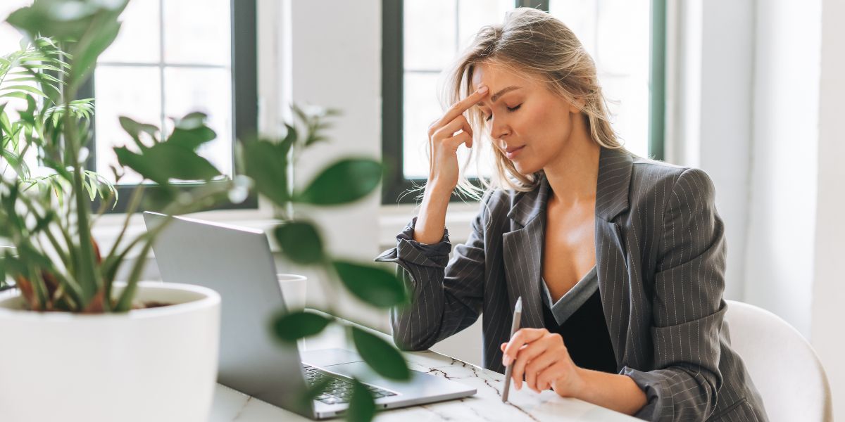 Woman sat at laptop looking sad after being ghosted after a job interview