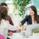 Women shaking hands over a table