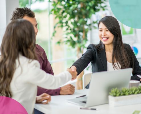 Women shaking hands over a table