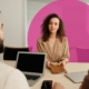 Woman set at desk opposite two other people, being interviewed for a job