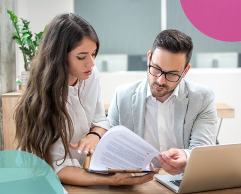 Two people reading through a printed CV